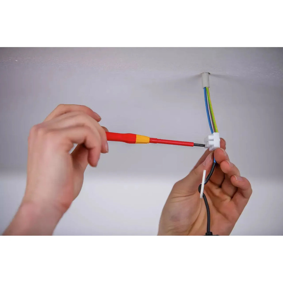 Person using a precision screwdriver to connect electrical wires
