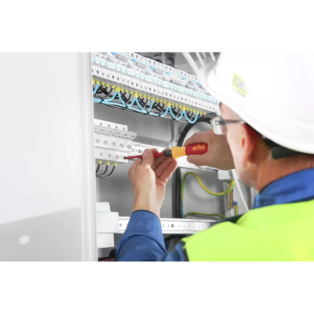 5-piece – Person using an electric screwdriver on electrical panel
