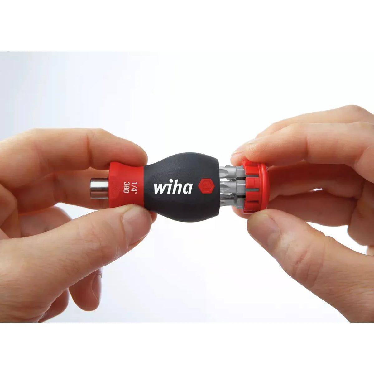 Phillips & Pozidriv – Hands holding a black and red bit holder with multiple bits