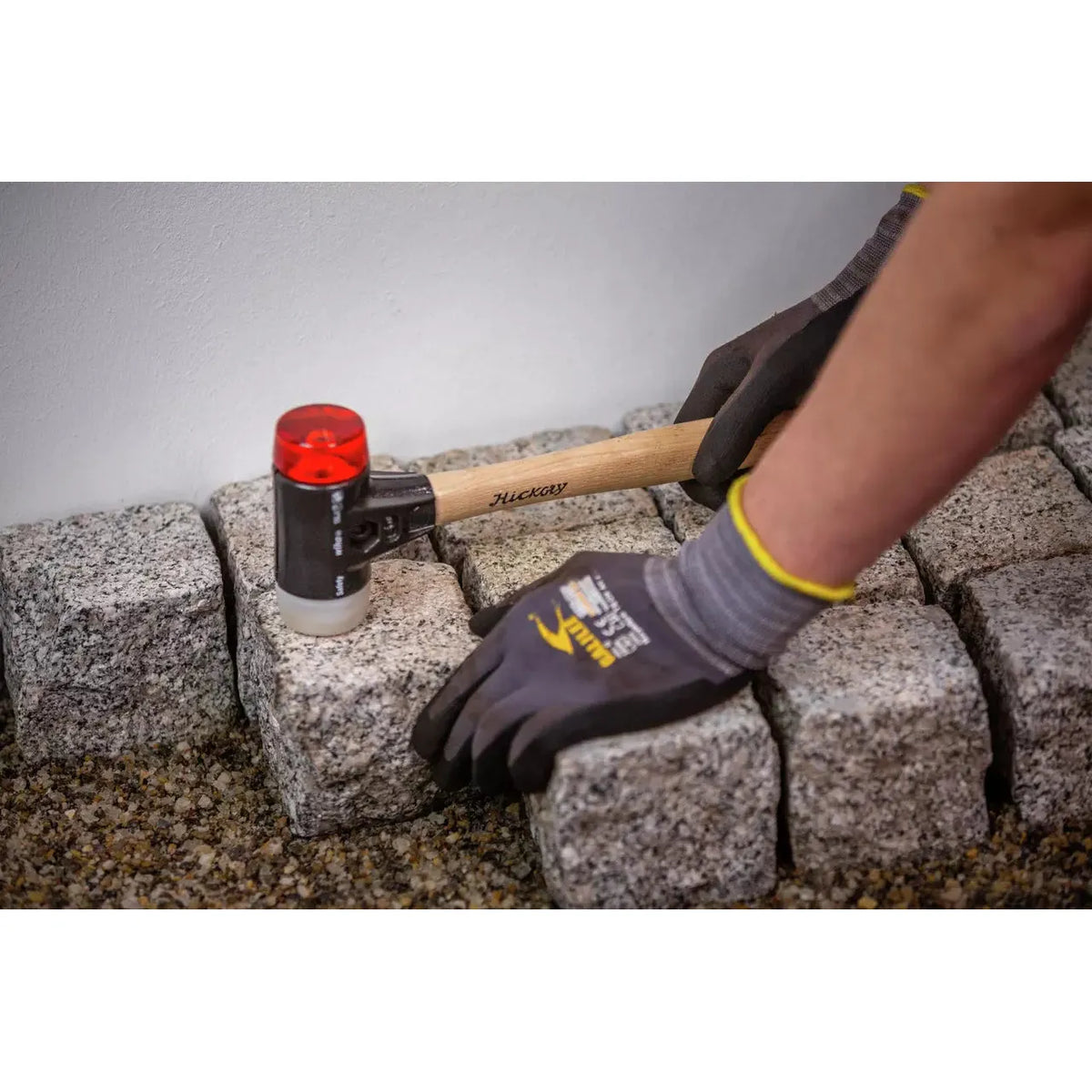 Person using mallet on paving stones