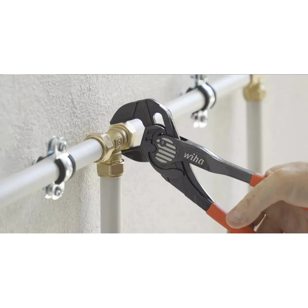 Adjustable wrench gripping a pipe fitting