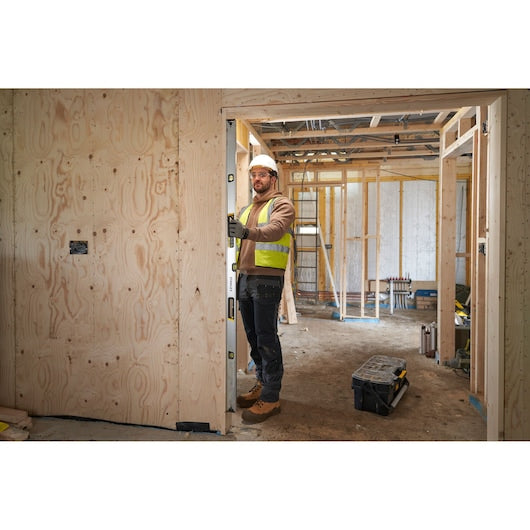 STANLEY FMHT43678-1 spirit level used by worker in timber frame construction site, photography of product in use.
