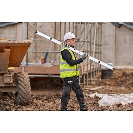 Photo of STANLEY FMHT43678-1 spirit level tool held by worker at construction site.