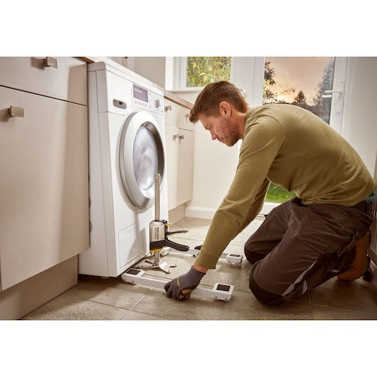 STANLEY FMHT83550-1 hand tool used to lift washing machine during kitchen installation.