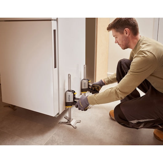 Photo of STANLEY FMHT83550-1 cabinet jack used to lift a white cabinet during installation.