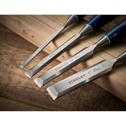 STANLEY 0-16-130 wood chisel set with four sizes, beveled edges, blue handles, angled on wooden surface.
