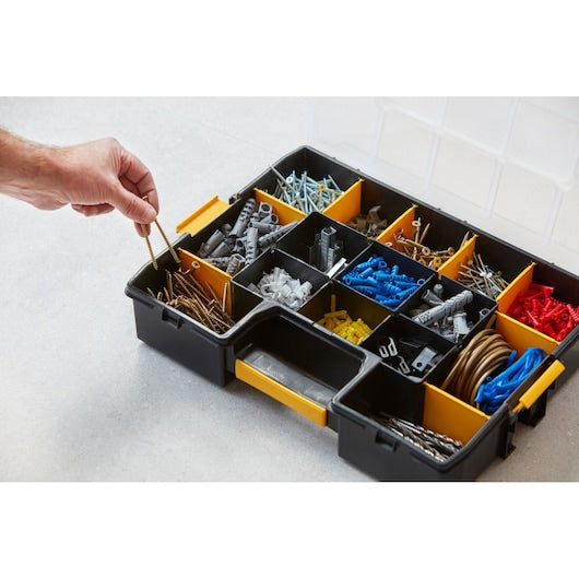 STANLEY 1-94-745 organizer box with compartments holding screws, wall plugs, and hardware, person picking screws.
