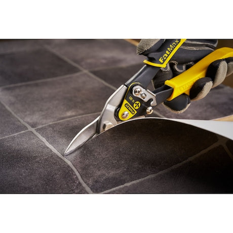 STANLEY 2-14-563 aviation snips with yellow handle cutting tile sheet close-up.