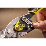 Close-up photo of STANLEY 2-14-563 aviation snips with yellow and black handle, finger pressing a metal latch.