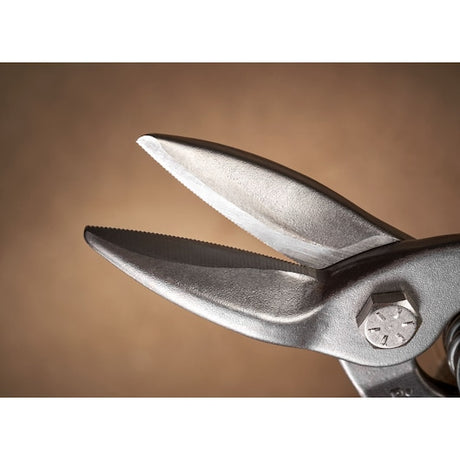 Close-up of STANLEY 2-14-563 aviation snips showing serrated steel blades against brown background.