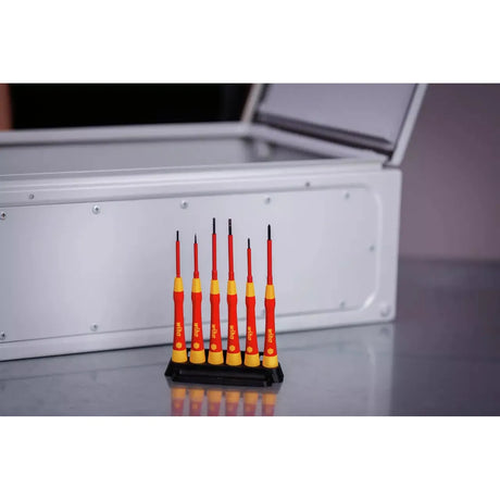 Set of six red and yellow precision screwdrivers in a black stand