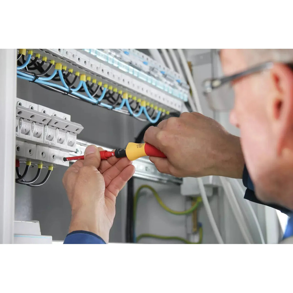 5-piece – Person using an electric screwdriver on electrical panel