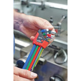 A person holds a set of colorful L-shaped hex keys in a red holder labeled "ErgoStar" in a workshop.