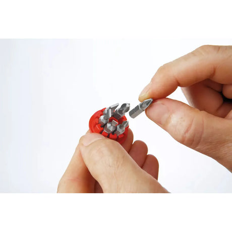 Phillips & Pozidriv – Hands holding a red bit holder with several metal bits, one being removed.