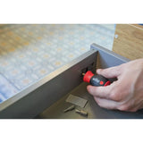 Phillips & Pozidriv – Hand using a stubby screwdriver to adjust a fitting in a drawer, with bits lying nearby.