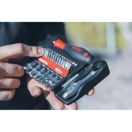 Person holding a tool kit with various screwdriver bits and sockets.
