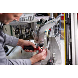Person using an electric screwdriver on a machine
