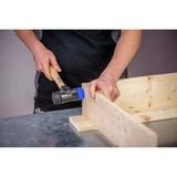 Person using a mallet with a wooden handle on a wooden structure.