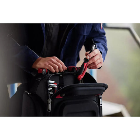 Person taking a tool from a black tool bag.