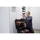 Person working on electrical panel with tool case open