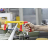 A person using a yellow and red hacksaw to cut a metal pipe clamped in a vise.