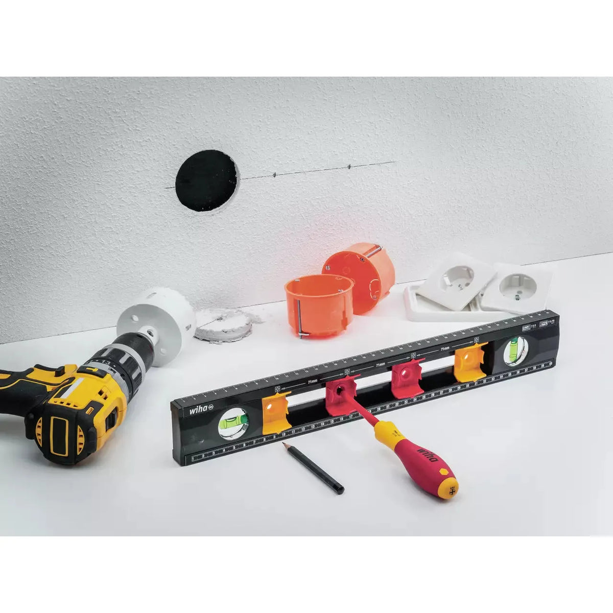 Electrician's level, drill, and socket parts on a white surface