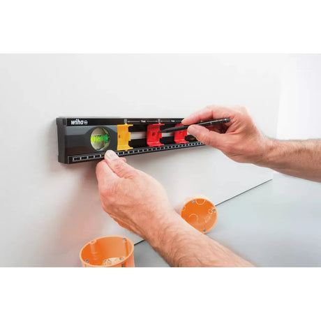 Person using a black level with colored markers on a wall