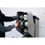12–1,000V AC – A person uses a non-contact voltage detector on an electrical panel with wires and circuit breakers.