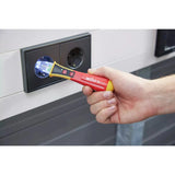 12–1,000V AC – Hand holding a red voltage detector near a power outlet, showing LED light