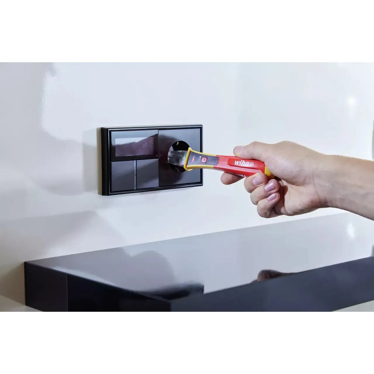 90–1,000V AC – Hand using voltage detector on wall socket
