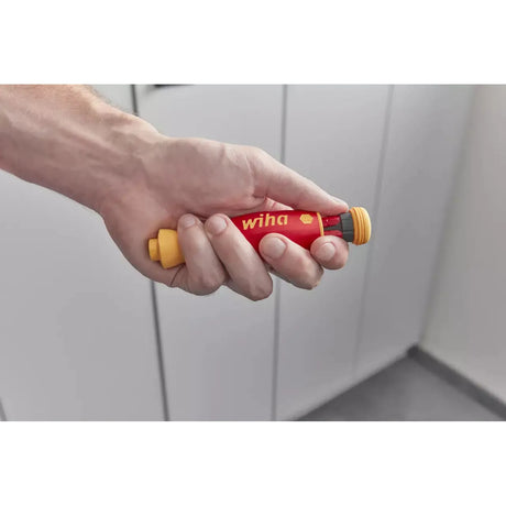 Hand holding a red and yellow electric screwdriver with a rounded grip