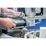 Person using a hex key set on a machine with bolts in the foreground.