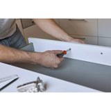 Person using screwdriver on white drawer in kitchen