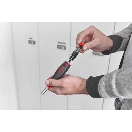 Person holding a screwdriver with a detachable bit holder