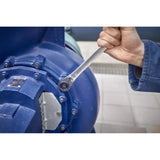 A person using a ratchet wrench to tighten a bolt on a large blue machine.