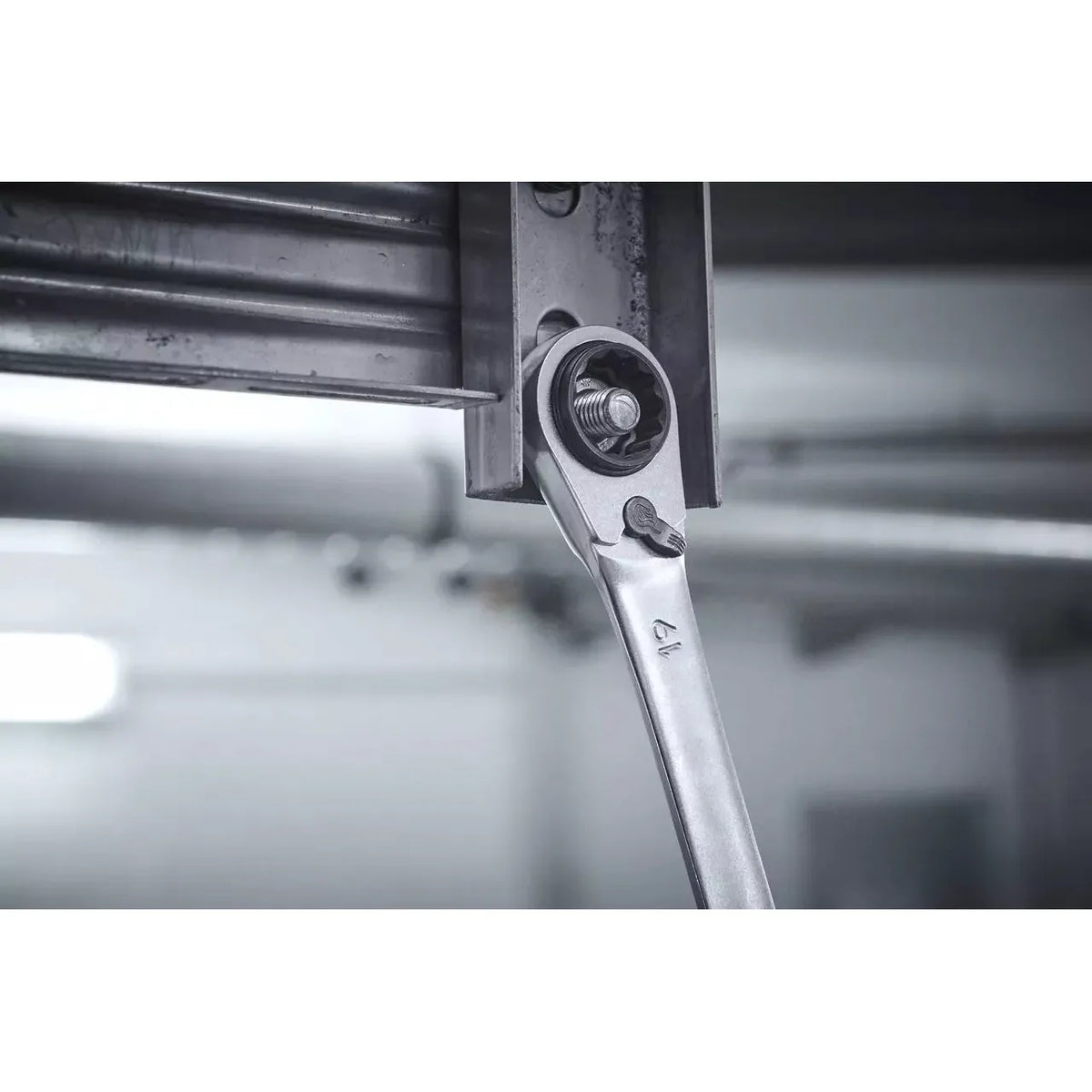 Ratchet wrench tightening a bolt on a metal frame