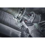 A hand in a glove uses a ratchet wrench on a metal garage door mechanism.