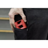 A person placing a red magnetizer tool into a pocket.
