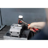 A person using a dead-blow hammer with a white head on a metal workpiece.
