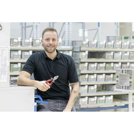 Person holding combination pliers in a warehouse