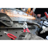 Person using diagonal cutters with red handles on a workbench