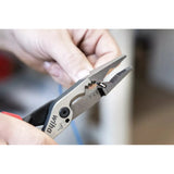 Person holding pliers working on a cable