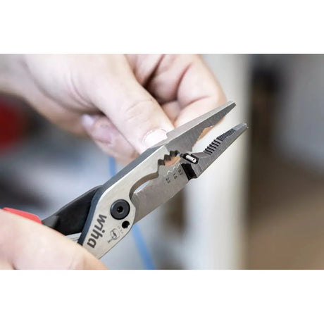 Person holding pliers working on a cable