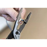 A hand uses pliers to strip insulation from a blue electrical wire.
