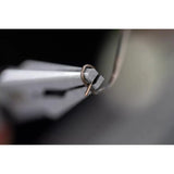 Close-up of pliers holding a bent metal wire loop