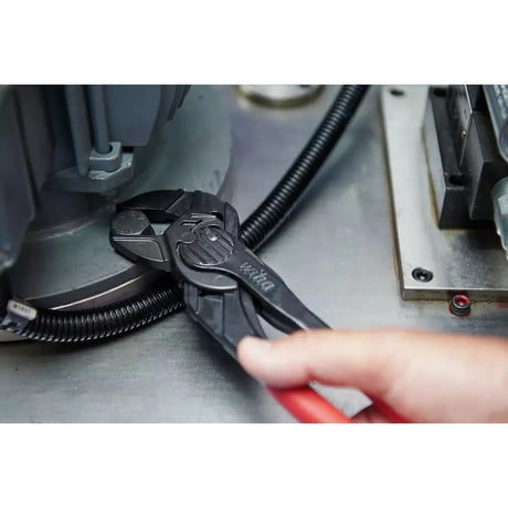 Adjustable wrench gripping a bolt, human hand visible
