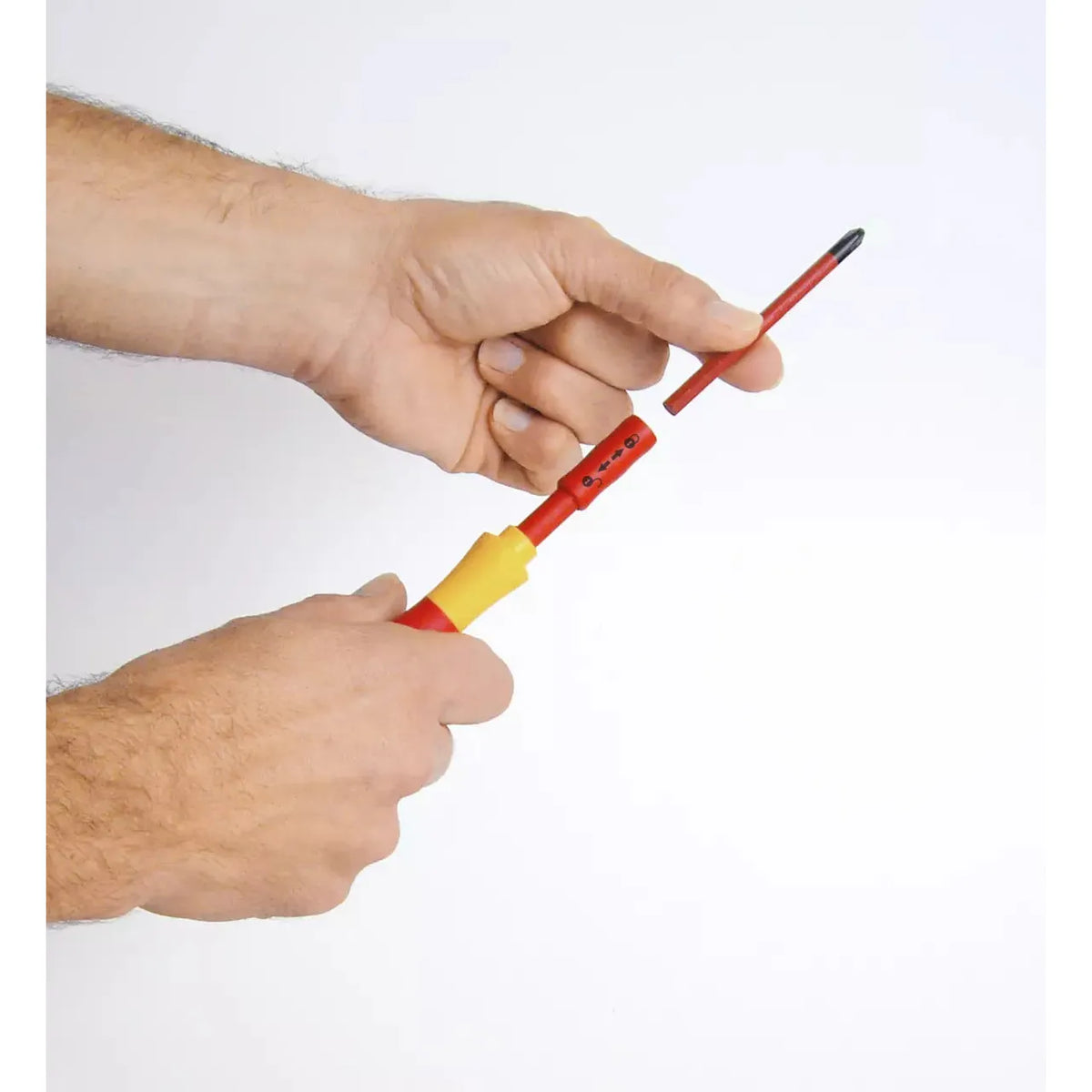 10-piece – Slotted, Phillips & Pozidriv – Hands holding and assembling a red and yellow screwdriver with a removable bit.