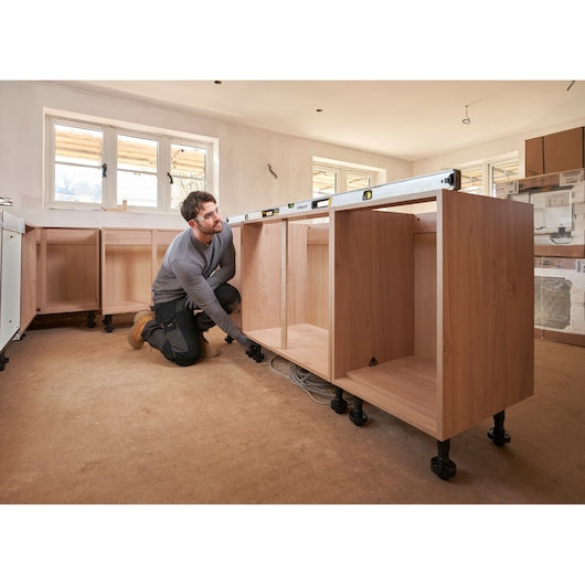 STANLEY FMHT43678-1 spirit level on wooden kitchen cabinet during installation, wide angle.