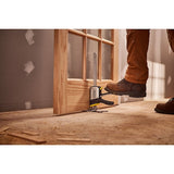 STANLEY FMHT83550-1 door installation tool in use, foot pressing lever, wooden door, construction site.
