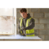 Photo of STANLEY STHT47311-0 construction worker using a tool on a jobsite, wearing a high-visibility vest.